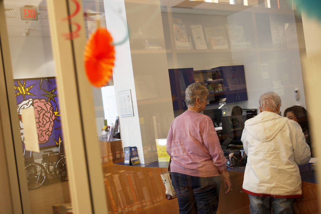 Los visitantes hablan con la recepcionista en el lobby de la Clínica Cleveland en Las Vegas, el lunes 26 de marzo de 2018. Un nuevo estudio publicado el martes por la Alzheimer's Association info ...