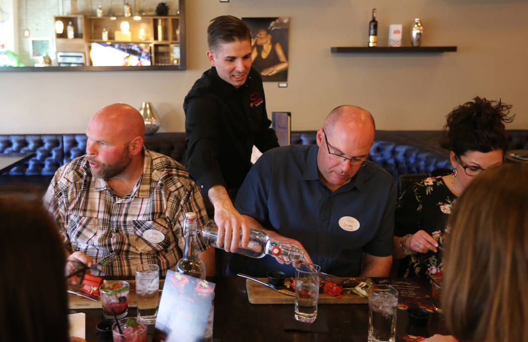 El presidente de Lip Smacking Foodie Tours: Donald Contursi, de pie, con Colin O'Neill, a la izquierda, y Greg O'Neill durante una parada de comida y bebida en Therapy, en el centro de Las Vegas, ...