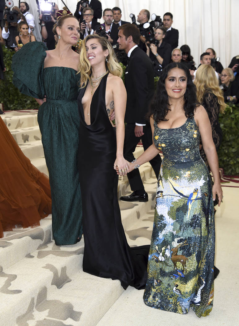Stella McCartney, desde la izquierda, Miley Cyrus y Salma Hayek asisten a la gala del Costume Institute del Museo Metropolitano de Arte que celebra la apertura de la exposición Heavenly Bodies: F ...