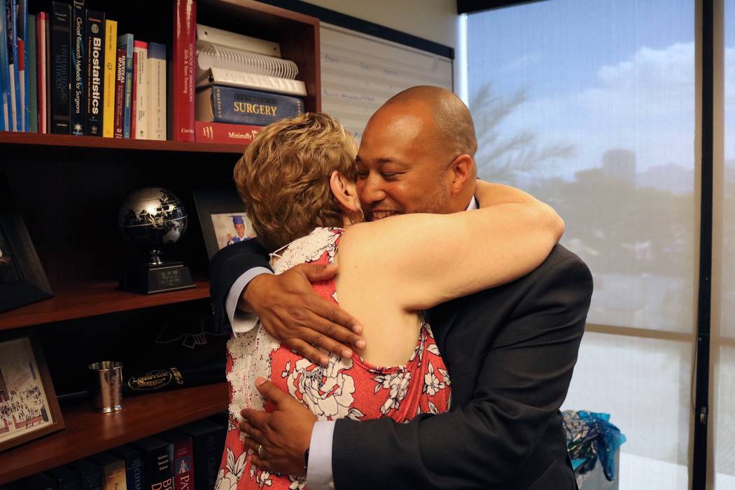 Mary Duda abraza al Dr. Charles St. Hill en las oficinas del Departamento de Cirugía de la UNLV en Las Vegas, el martes 22 de mayo de 2018. St. Hill realizó la oncología pancreatoduodenal de Du ...