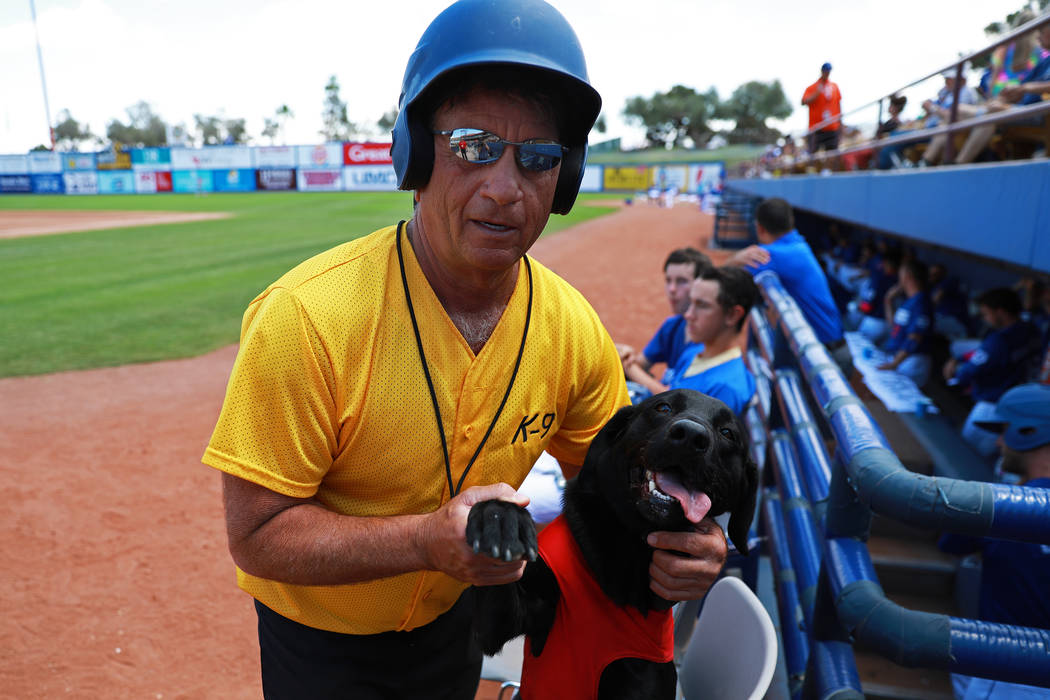 Fred Hassen, fundador del entrenamiento de perros Sit Means Sit, posa para una fotografía con el perro de los bates Finn de las Vegas 51s en el Cashman Field de Las Vegas el domingo 13 de mayo de ...