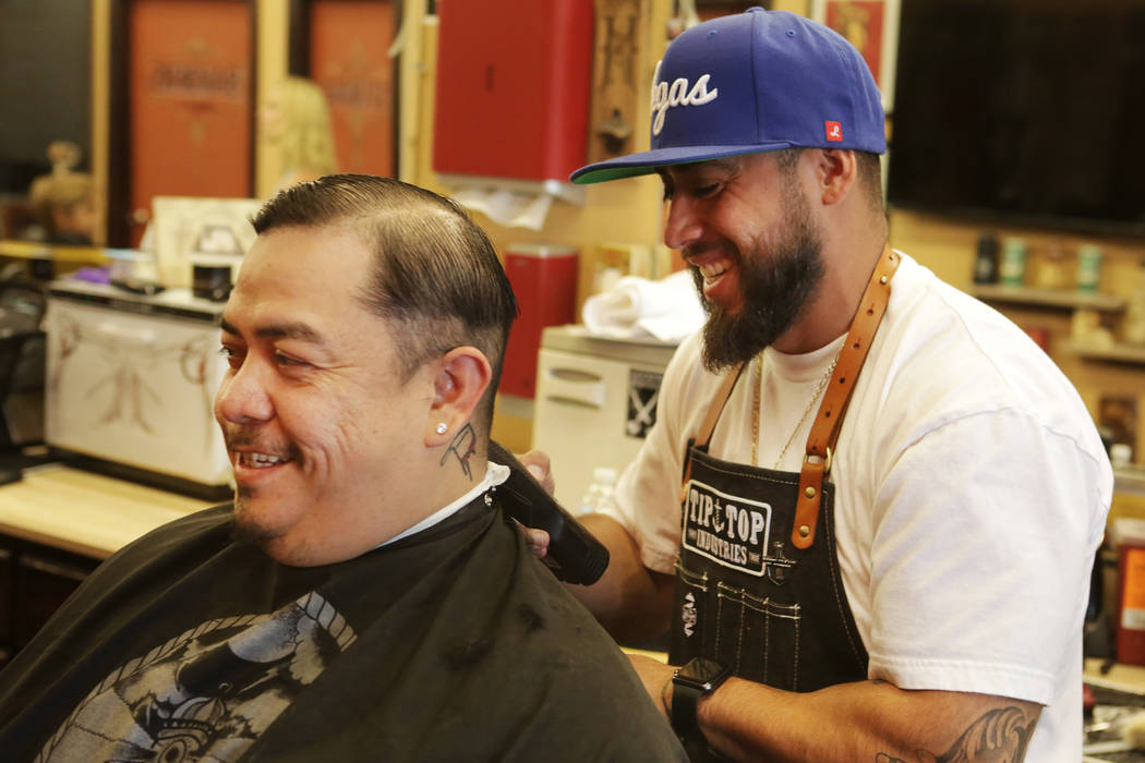 Moises "Moy The Barber" Álvarez, a la derecha, propietario de Goodtimes Barber Shop & Shave Parlor en Sahara en Las Vegas, pone los toques finales a un corte de cabello de Golden Knights para Fer ...