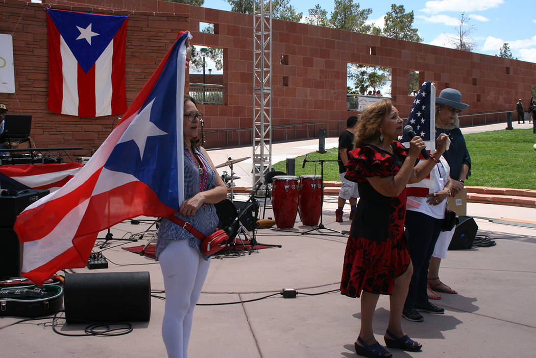 Ana Acevedo sostiene la bandera de Puerto Rico y Mónica Ortiz canta el himno de la isla, el 27 de mayo del 2018, en el anfiteatro del gobierno del Condado Clark. Foto Valdemar González / El Tiem ...