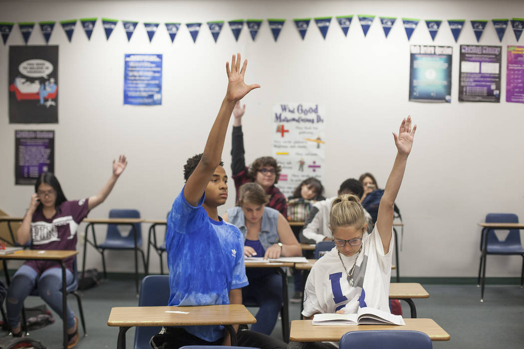 D'Andre Burnett, izquierda, levanta la mano para responder una pregunta junto a Marykate Springer en la clase de matemáticas en Shadow Ridge High School en Las Vegas, miércoles 16 de mayo de 201 ...
