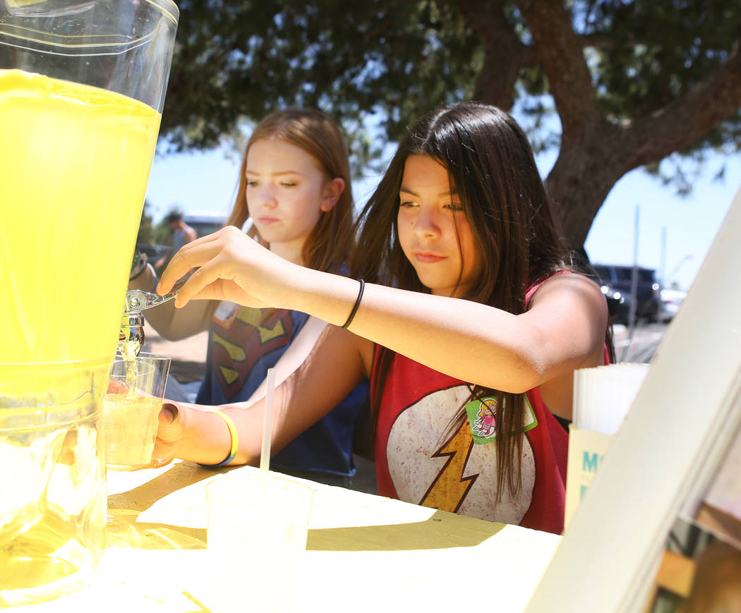 Mallory Poushay, de 13, izquierda, y Alyciana Rivas, de 13, reparten limonada durante la recaudación de fondos de Alex's Lemonade Stand Foundation para la investigación de cáncer infantil en Su ...