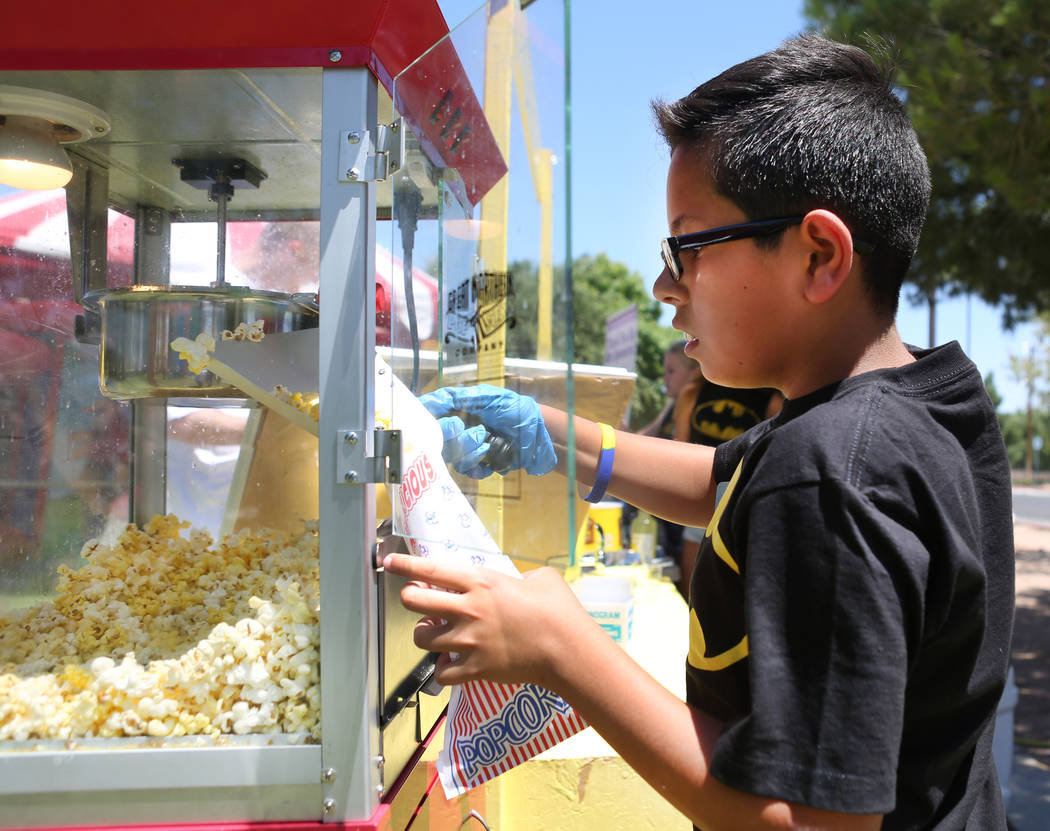 Tommy Ramos, de 11 años, prepara palomitas de maíz durante una recaudación de fondos para Alex's Lemonade Stand Foundation, una fundación nacional contra el cáncer infantil, en Sunset Park en ...