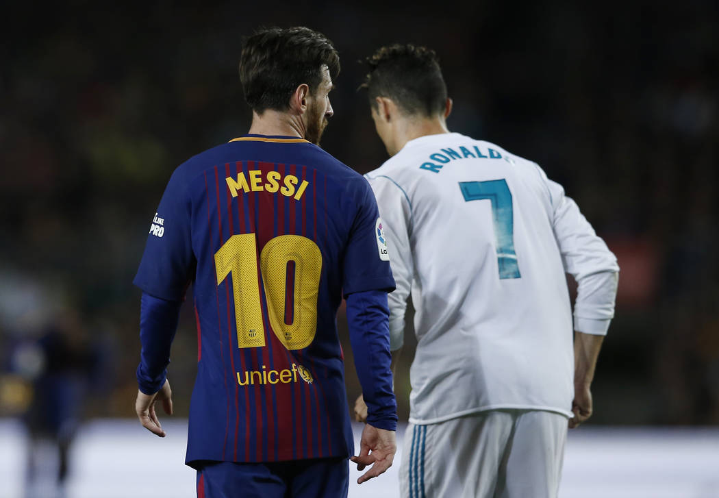 Lionel Messi, del Barcelona, y Cristiano Ronaldo, del Real Madrid, retroceden para tomar posiciones durante un partido de fútbol de la Liga española entre el Barcelona y el Real Madrid, denomina ...