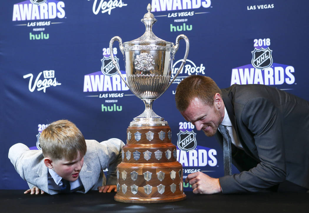 Henrik Sedin de Vancouver Canucks, con su hijo Harry, se ve el Rey Clancy Memorial Trophy durante los Premios NHL en el Hard Rock Hotel de Las Vegas el miércoles 20 de junio de 2018. Chase Steven ...
