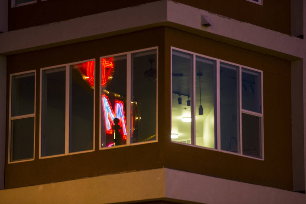 Un letrero de neón se refleja en el edificio de apartamentos Fremont9, programado para abrir más tarde este otoño, en el centro de Las Vegas el viernes 22 de junio de 2018. Chase Stevens Las Ve ...