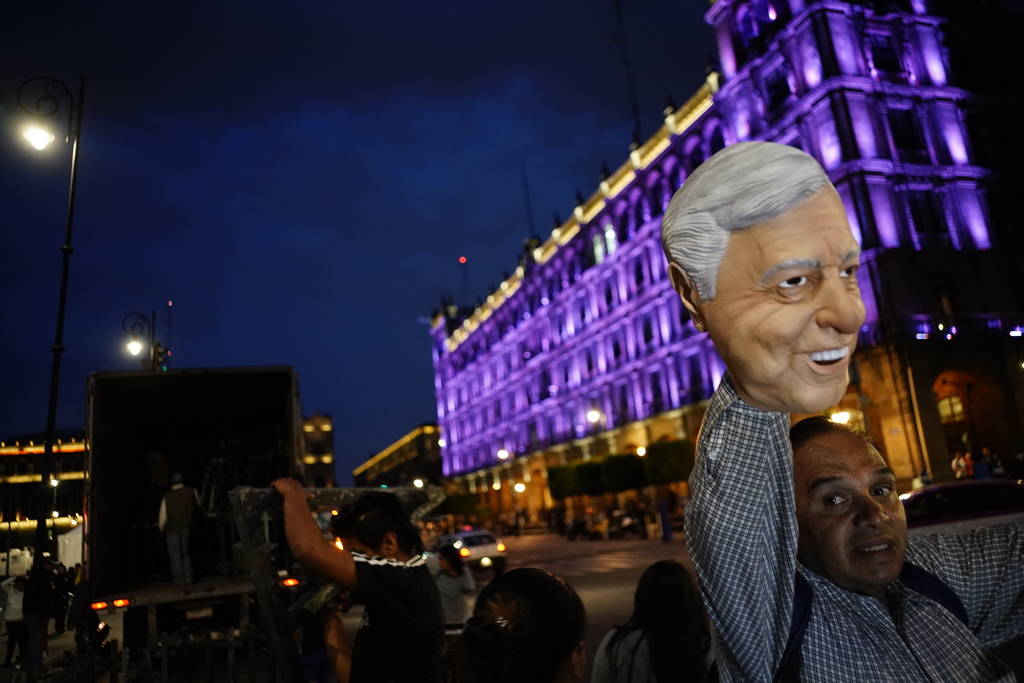 Un vendedor ambulante vende una máscara de Andrés Manuel López Obrador en la plaza principal de la Ciudad de México, el Zócalo, el domingo 1 de julio de 2018. López Obrador está a punto de ...