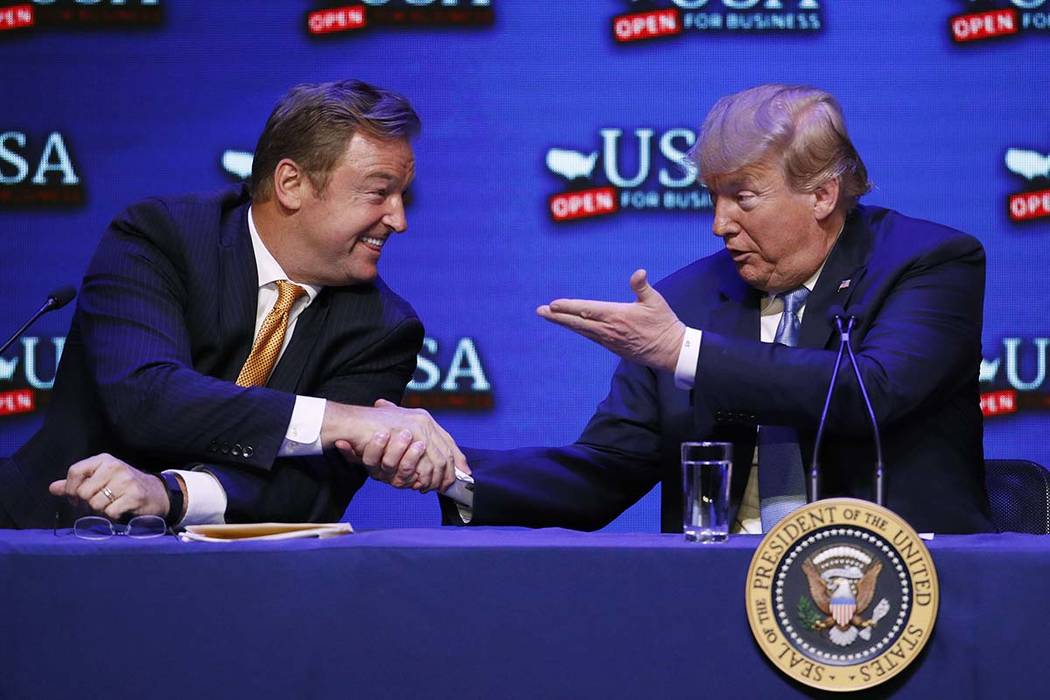 El presidente Donald Trump, a la derecha, le da la mano al senador Dean Heller, republicano por Nevada, durante una mesa redonda sobre la reforma tributaria el sábado 23 de junio de 2018 en Las V ...