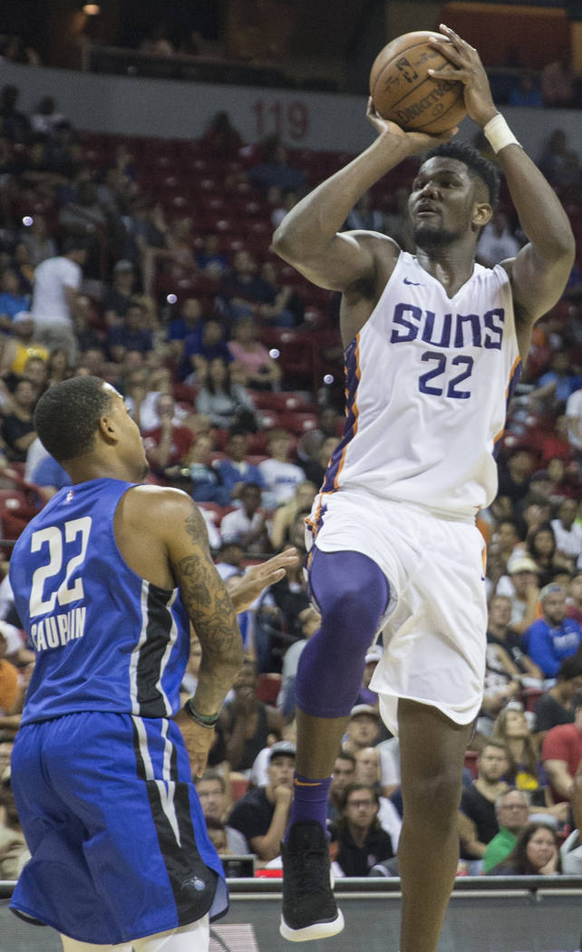 El centro de los Phoenix Suns, Deandre Ayton (22), tira sobre el guardia de Orlando Magic, Troy Caupain (22), en el segundo trimestre durante la Liga de verano de la NBA el lunes 9 de julio de 201 ...