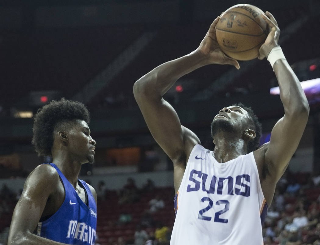 El centro de los Phoenix Suns, Deandre Ayton (22), pasa por delante del alero de Orlando Magic, Jonathan Isaac (1), en el tercer cuarto durante la NBA Summer League el lunes 9 de julio de 2018 en ...