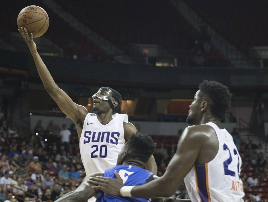 El alero de los Phoenix Suns, Josh Jackson (20), pasa por el centro de Orlando Magic, Mohamed Bamba (5), en el segundo trimestre durante la Liga de verano de la NBA el lunes 9 de julio de 2018 en ...