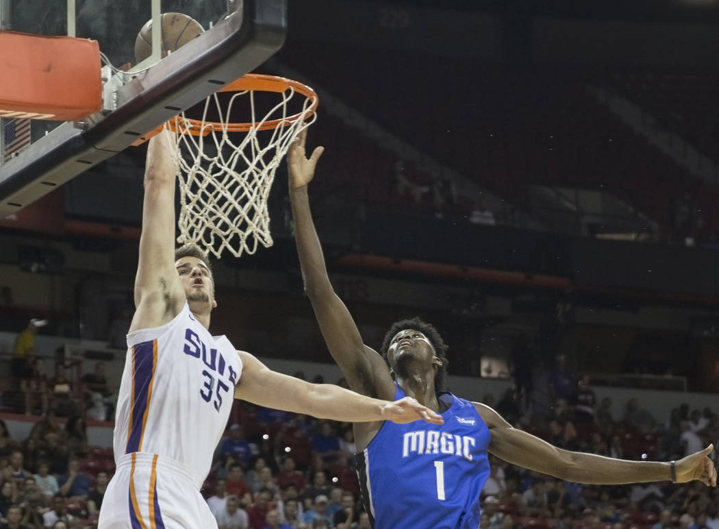 El alero de los Phoenix Suns, Dragan Bender (35), supera al alero del Orlando Magic, Jonathan Isaac (1) en el segundo trimestre durante la Liga de verano de la NBA el lunes 9 de julio de 2018 en e ...