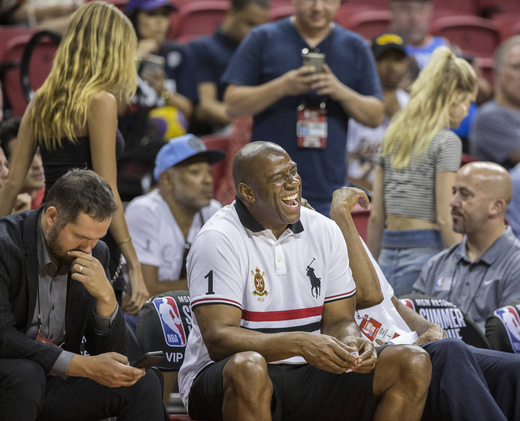 El ex jugador de los Lakers y actual gerente general, Magic Johnson, comparte una sonrisa con sus amigos durante el juego de la NBA Summer League de Los Ángeles con los New York Knicks el martes ...