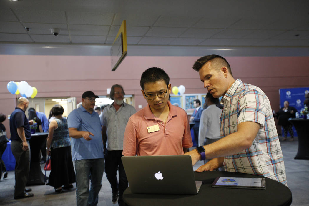 Un representante de Apple le habla a Qiang Li sobre las aplicaciones Swift de Apple que ofrecen maneras de aprender códigos a través de juegos en el College of Southern Nevada en Las Vegas, el j ...