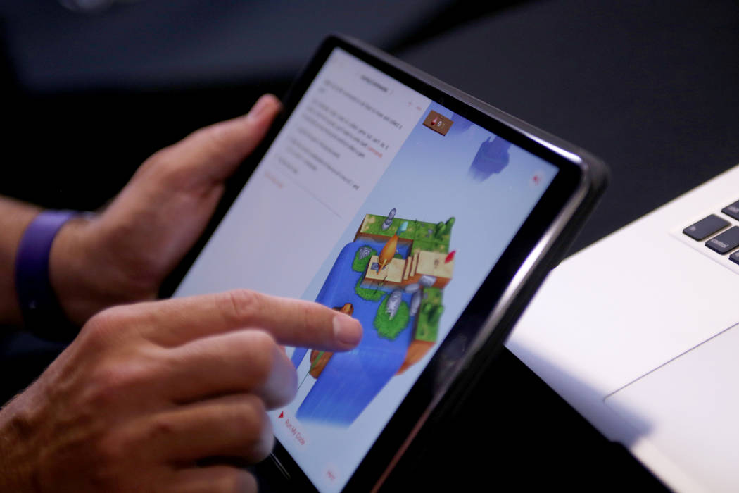 Un representante de Apple juega con una aplicación Swift que ofrece formas de aprender códigos a través de los juegos en el College of Southern Nevada en Las Vegas, el jueves 12 de julio de 201 ...