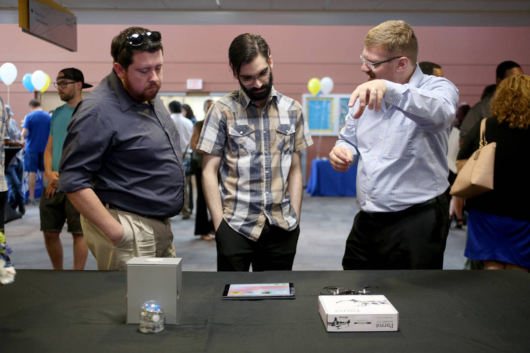 David Clark, izquierda, y Roger Cruz escuchan a Joerg Radler, un ingeniero de Apple, en College of Southern Nevada en Las Vegas, el jueves 12 de julio de 2018. Radler explicó cómo los estudiante ...