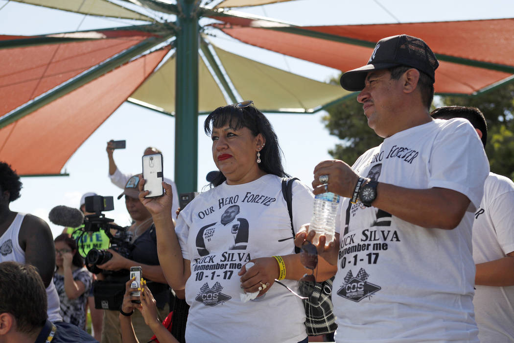 Angélica Cervantes, izquierda, y su esposo Gregorio De La Rosa miran cómo Manny Oliver crea un mural en una Caminata de Registro de Votantes de Road to Change en Sunset Park en Las Vegas, el lun ...