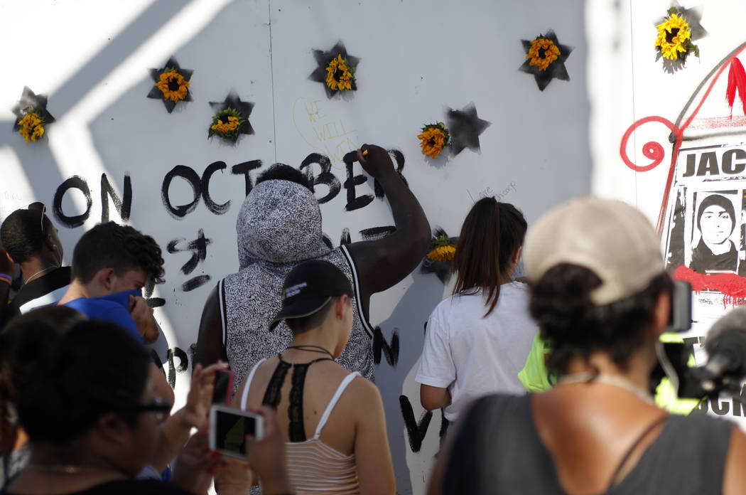 Las personas firman un mural realizado por Manny Oliver en un Road to Change Voter Registration Walk en Sunset Park en Las Vegas, el lunes 16 de julio de 2018. El evento fue organizado por el grup ...