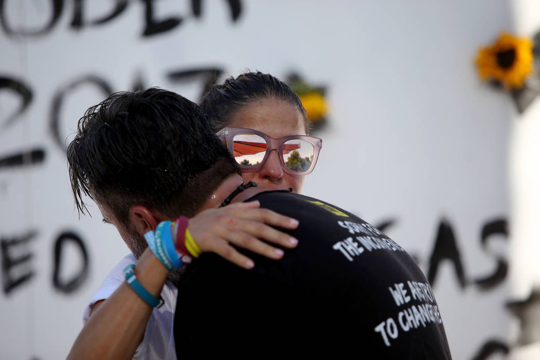 Patricia Oliver abraza a su esposo Manny Oliver después de pintar un mural en una Caminata de Registro de Votantes de Road to Change en Sunset Park en Las Vegas, el lunes 16 de julio de 2018. El ...