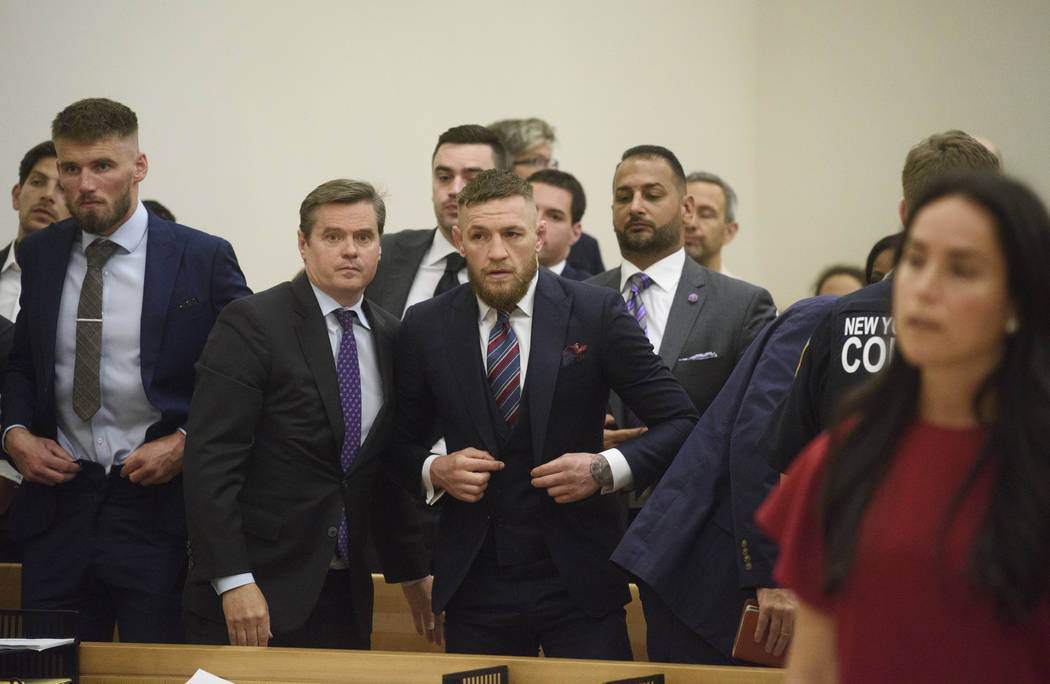 Conor McGregor, del centro, aparece en la corte junto con el acusado Cian Cowley, a la izquierda, durante una audiencia, el jueves 26 de julio de 2018, en el distrito de Brooklyn en Nueva York. La ...