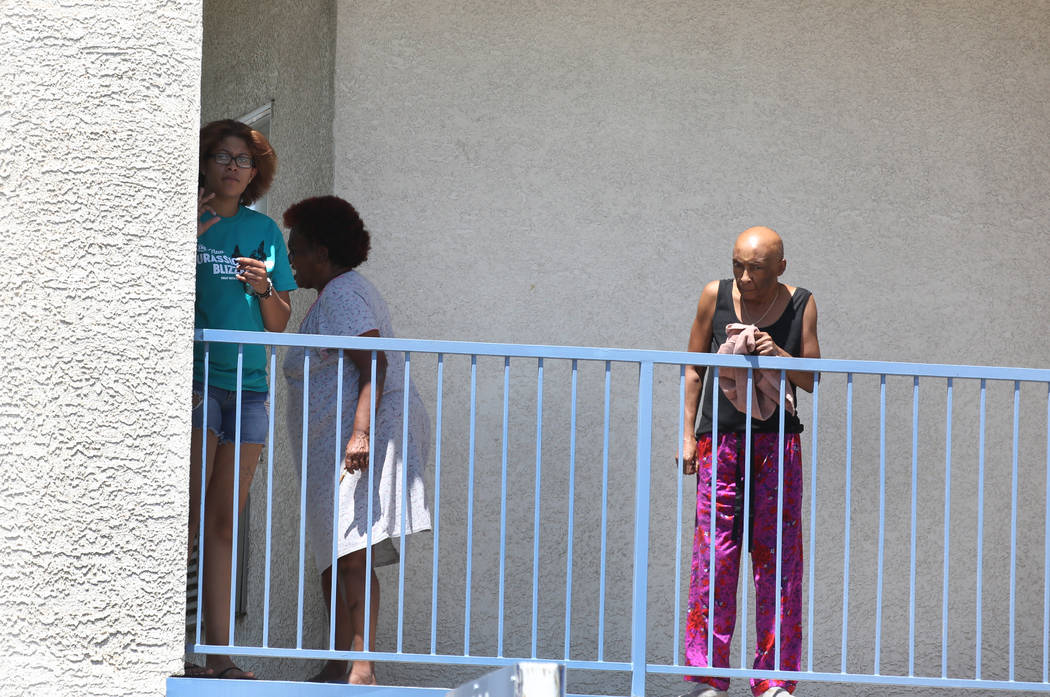 Los residentes de Kensington Suites en la cuadra 2200 de West Bonanza Road miran mientras la policía de Las Vegas está investigando un tiroteo que involucró a un oficial, el lunes 6 de agosto d ...