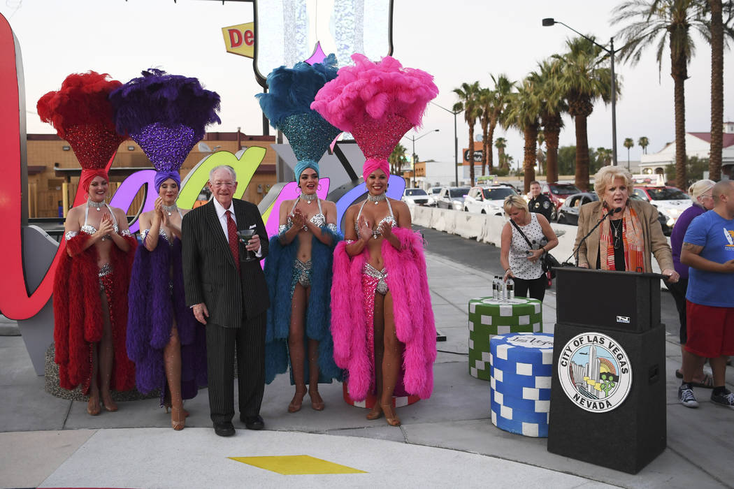 La alcaldesa de Las Vegas, Carolyn Goodman, habla mientras el presidente del Comité Organizador de LVCVA, Oscar B. Goodman, posa con showgirls mientras se inaugura un nuevo letrero de Las Vegas e ...