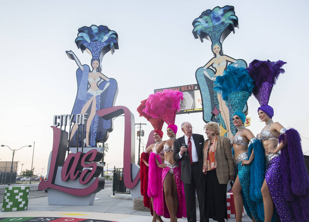La alcaldesa de Las Vegas, Carolyn Goodman, tercera desde la derecha, se toma fotos con su esposo y ex alcalde de Las Vegas, Oscar Goodman y un grupo de showgirls durante una ceremonia de dedicaci ...