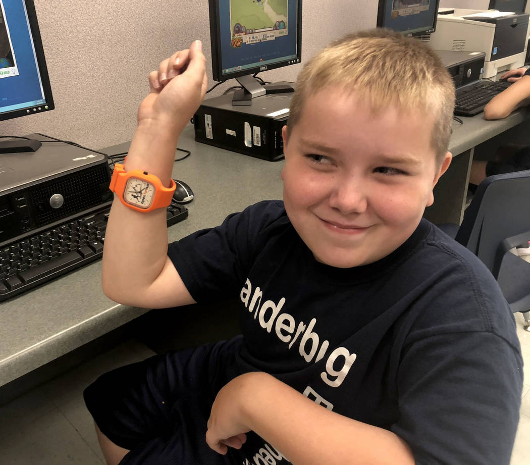 Dylan Chalmers, de siete años, estudiante de segundo grado con parálisis cerebral, trabaja en una computadora después de la escuela en la Primaria Vanderburg con su padre, Scott, el 24 de agost ...