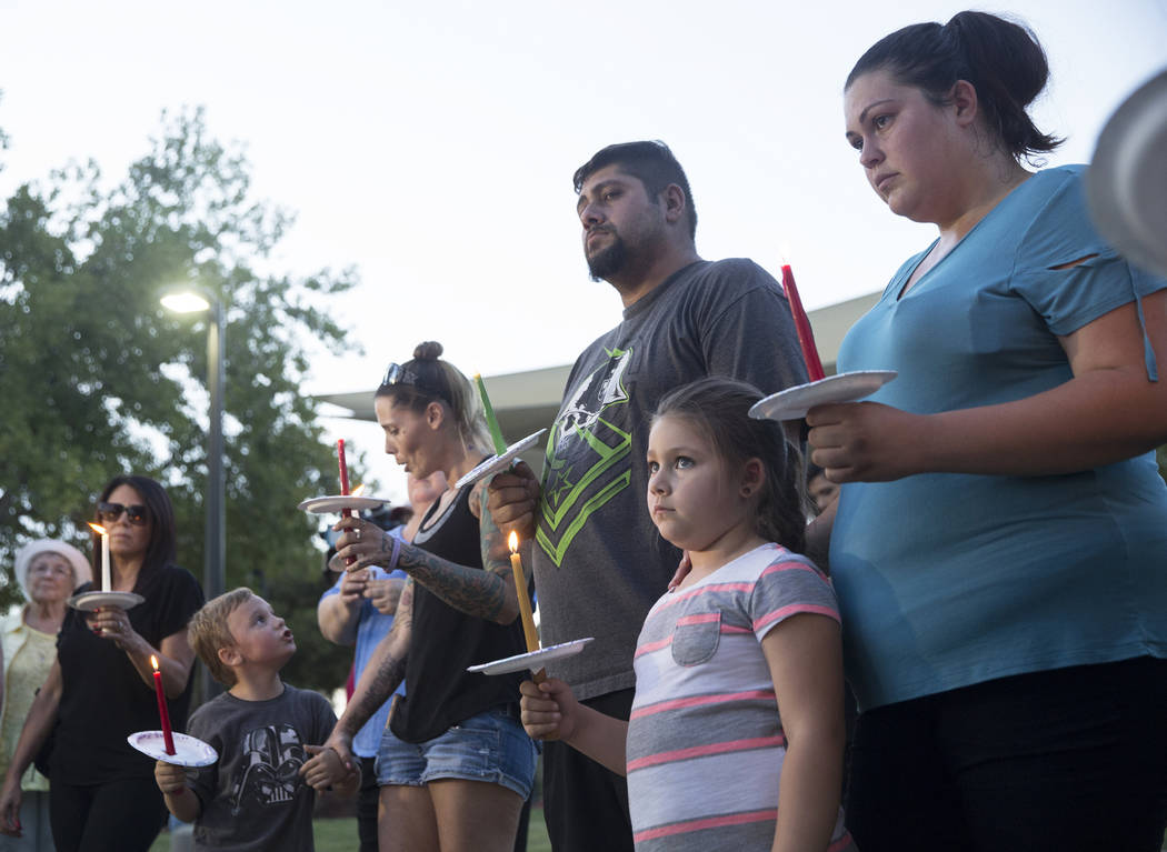 Jasmine González, abajo/derecha, de cinco años, sostiene una vela durante un velorio por Levi Echenique, Daniel Theriot y Dejah Hunt en Sunset Park el martes 4 de septiembre de 2018 en Las Vegas ...