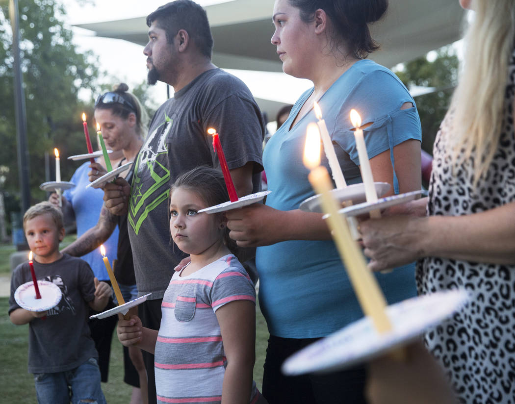 Jasmine González, abajo/medio, 5, sostiene una vela durante un velorio por Levi Echenique, Daniel Theriot y Dejah Hunt en Sunset Park el martes 4 de septiembre de 2018 en Las Vegas. Benjamin Hage ...