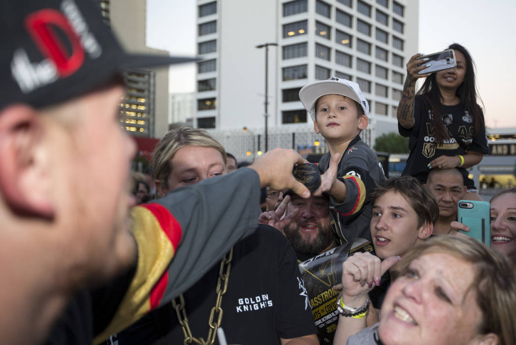 Jaxon Galvan, de 6 años, recibe su puck autografiado por el defensor de los Vegas Golden Knights, Nate Schmidt, izquierda, durante una fiesta de los fans de los Vegas Golden Knights en el Centro ...