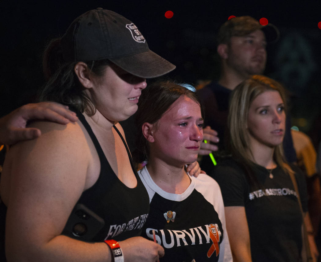 Brittany Maldonado, a la izquierda, y Alaina Laswell lloran mientras relatan el tiroteo de One October un año más tarde fuera del estacionamiento donde ocurrió el tiroteo en Las Vegas, el 1 de ...
