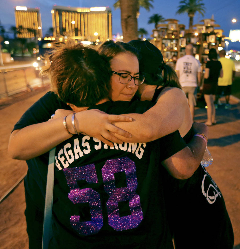 Liafaith Fischer, de frente, abraza a Cindy Loveless, y Jamie Steele en el cartel de Welcome to Fabulous Las Vegas en el primer aniversario del tiroteo en Strip del 1 de octubre. K.M. Cannon Las V ...