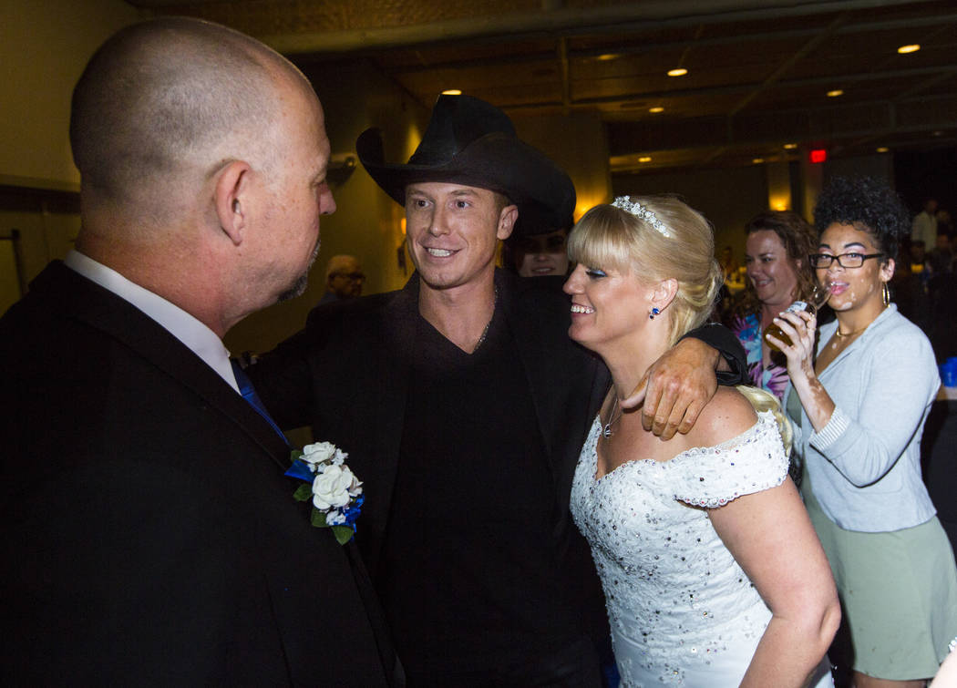 El músico country Sam Riddle, en el centro, saluda a Todd y Oshia Wienke durante la recepción de su boda en Tahiti Village en Las Vegas el lunes 1 de octubre de 2018. Todd recibió tres disparos ...