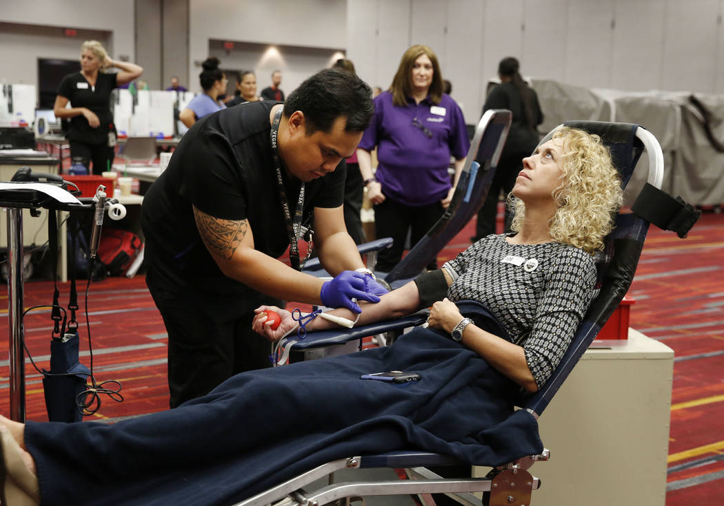 Ivan Puzon, especialista en cuidado de donantes, extrae sangre de Kelly Messing en el Centro de Convenciones de Las Vegas el lunes 1 de octubre de 2018, durante una campaña de donación de sangre ...