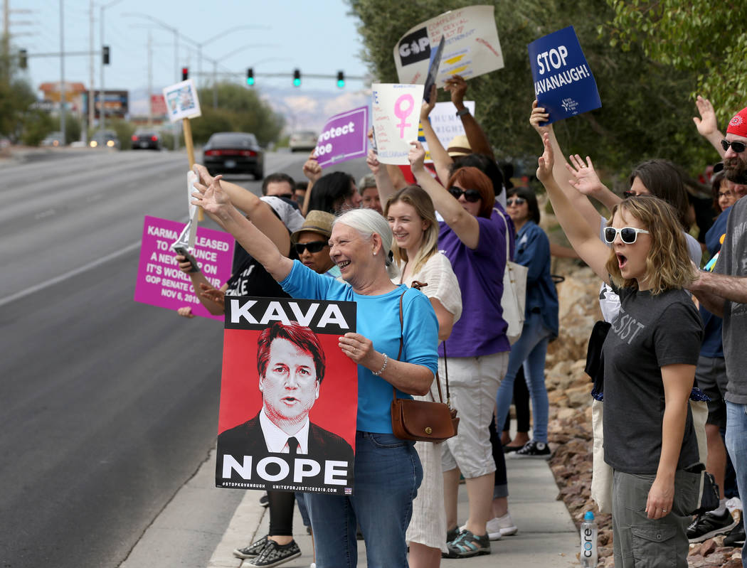 La gente saluda a los coches que pasan en un mitin que se opone a la confirmación del nominado a la Corte Suprema Brett Kavanaugh en las oficinas de For Nevada's Future en Las Vegas el sábado 6 ...