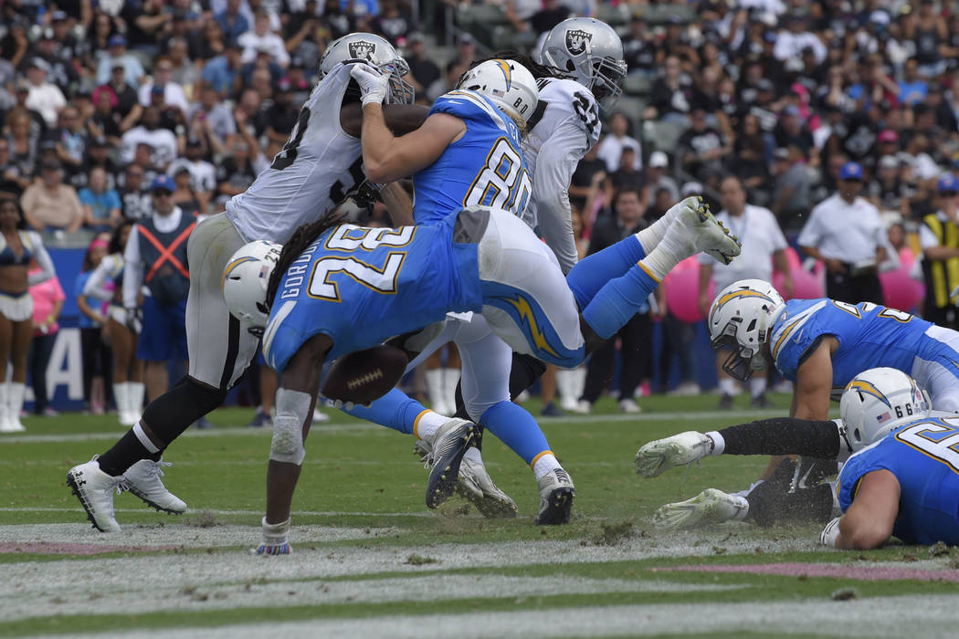 El corredor de Los Ángeles Chargers, Melvin Gordon, centro, anotó un touchdown durante la primera mitad de un partido de fútbol de la NFL contra los Raiders de Oakland el domingo 7 de octubre d ...