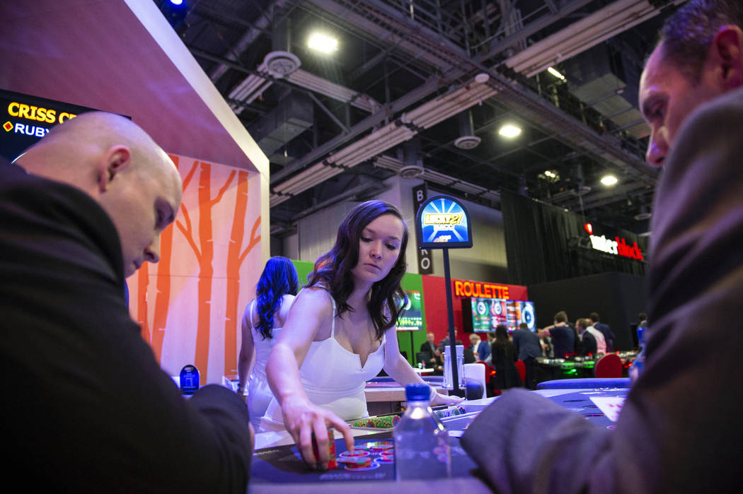 Olivia Paiz, de Las Vegas, reparte fichas de póquer en la mesa de AGS Criss Cross Poker en la 18ª Exposición Global de Juegos en el Sands Expo and Convention Center en Las Vegas, el miércoles ...