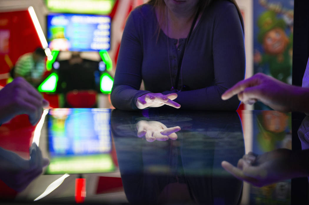 Los asistentes juegan un juego de mesa con el tema de Deal or No Deal que utiliza tecnología de pantalla táctil en el stand de Gamblit en la 18º Global Global Expo en Sands Expo and Convention ...