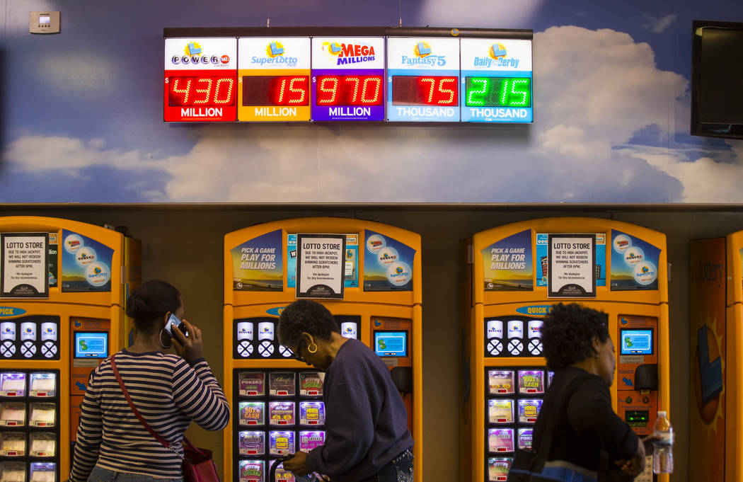 Los premios de lotería se muestran digitalmente en la tienda de lotería de Primm Valley mientras la gente espera para comprar los boletos de lotería de Mega Millions en Primm el jueves, 18 de o ...