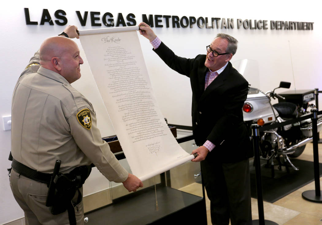 El teniente Harry Fagel, de la policía de Las Vegas, y Patrick Duffy, presidente y director ejecutivo de la Escuela de Artes de Nevada, presentaron el pergamino del poema "La Ruta" en la sede del ...