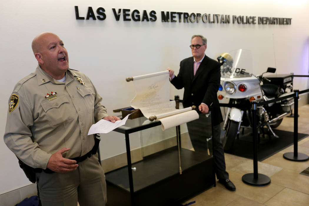 El teniente Harry Fagel, de la policía de Las Vegas, y Patrick Duffy, presidente y director ejecutivo de la Escuela de Artes de Nevada, presentaron el pergamino del poema "La Ruta" en la sede del ...