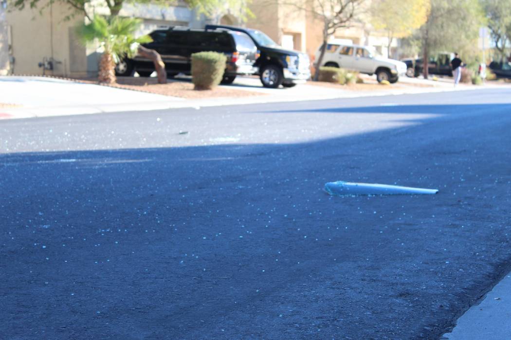 Los vidrios rotos se dispersan en la calle el viernes 2 de noviembre de 2018, cerca de una casa en la cuadra 6700 de Courtney Michelle Street, en North Las Vegas, que fue atacada con disparos y ma ...