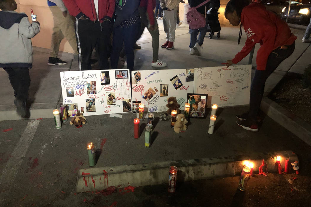 Una mujer ajusta los carteles que rinden tributo a LaMadre Harris durante un velorio el miércoles por la noche. El menor de 16 años murió después de recibir un disparo en North Las Vegas el ma ...