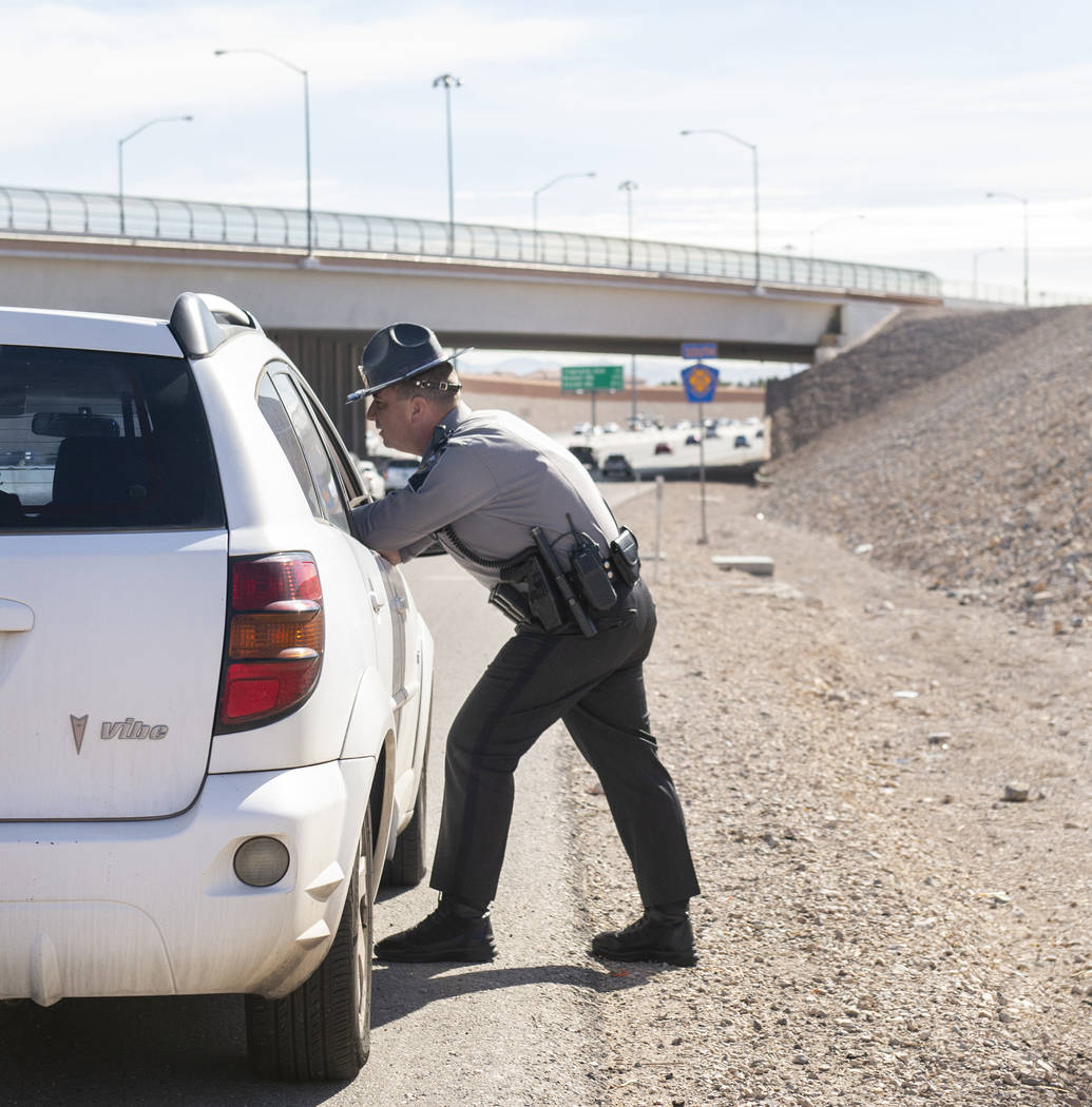 Jason Buratczuk, oficial de información y educación pública de la Patrulla de Carreteras de Nevada, habla con una conductora después de detenerla por exceso de velocidad en el 215 Beltway en L ...