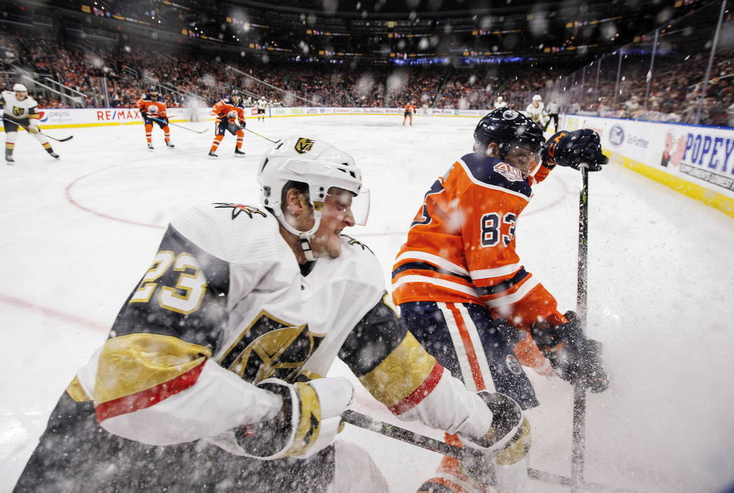 Daniel Carr (23) de los Golden Knights de Vegas y Matthew Benning (83) de los Edmonton Oilers luchan por el disco durante el tercer período de un juego de hockey de la NHL el sábado 1 de diciemb ...