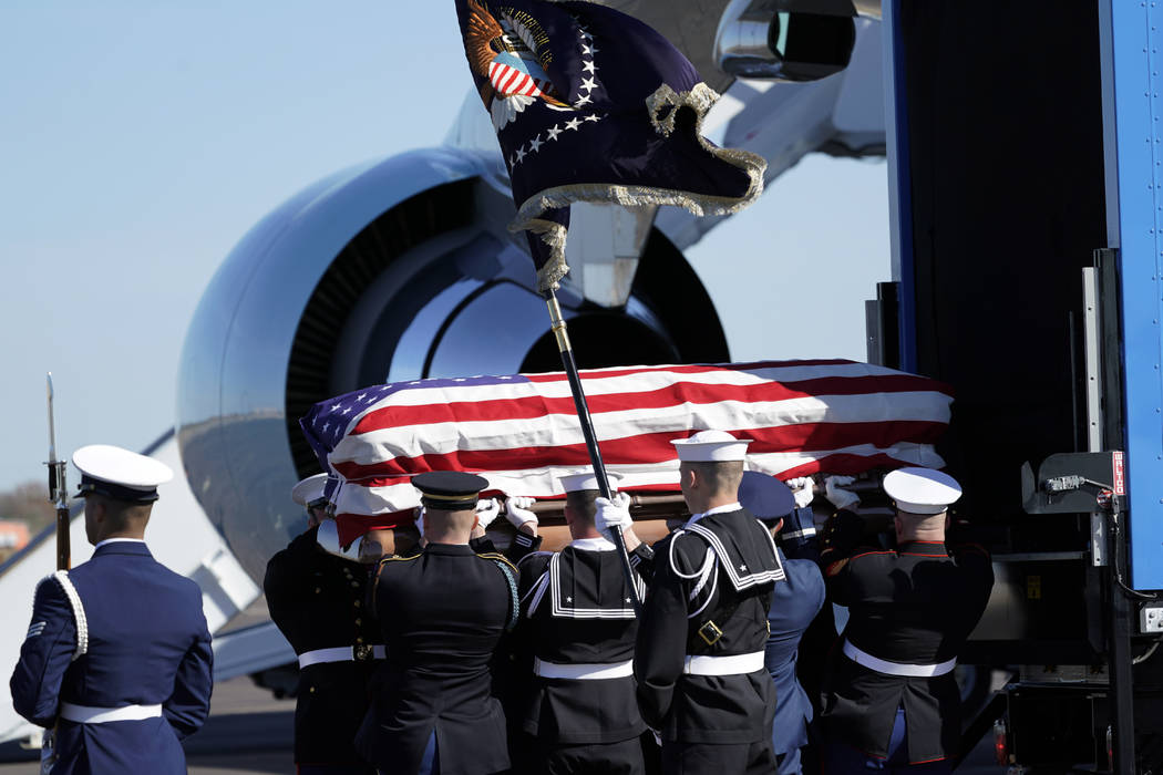 El ataúd abanderado del ex presidente George H.W. Bush es llevado por una guardia de honor militar de servicios conjuntos a la Misión Aérea Especial 41 en Ellington Field durante una ceremonia ...